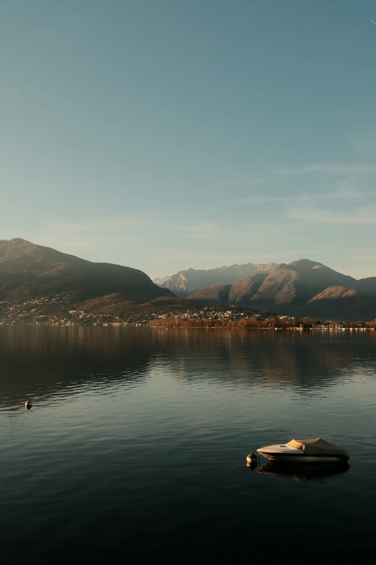 Lago in Ticino al tramonto, una barca ormeggiata